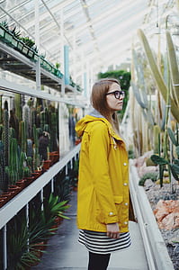 woman standing next to green cactus plants thumbnail