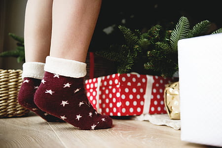 person wearing crew sock standing near Christmas tree thumbnail