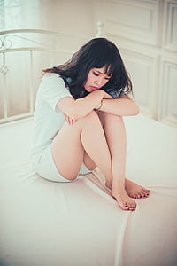 woman wearing white shirt sitting on white mattress thumbnail
