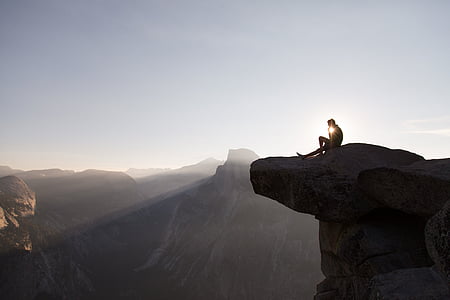 man sitting on top of mountain during daytime thumbnail