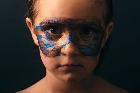 girl with blue and brown paint on face thumbnail