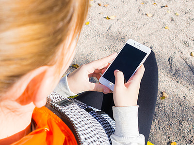 woman wearing orange and white long-sleeved shirt holding silver iPhone 6 thumbnail