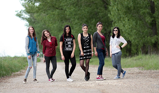 focus photography of six women taking picture behind trees thumbnail