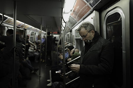 shallow focus photography of man leaning on door train thumbnail