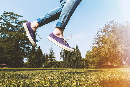 Female legs jumping on the grass outdoors in the park thumbnail