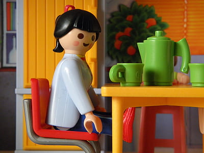 female sitting on chair at table plastic toy thumbnail