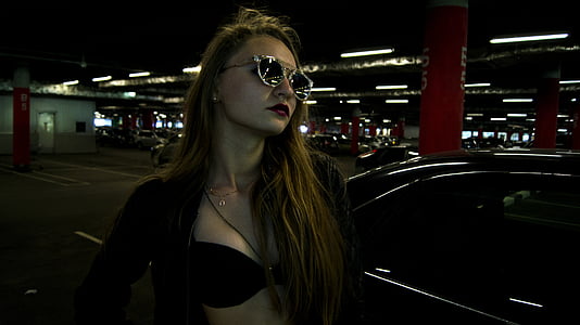 woman standing near black vehicle wearing black zip-up jacket thumbnail