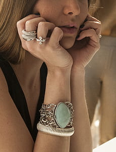 woman wearing silver-colored rings and bracelet taking photo in close-up thumbnail