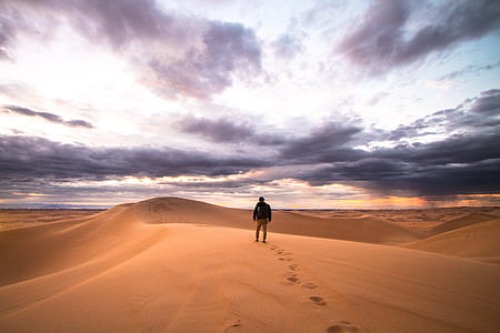 man walking on desert land thumbnail