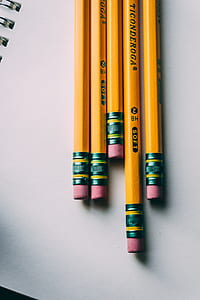 five yellow Ticonderoga pencils on white spiral notebook close-up photography thumbnail