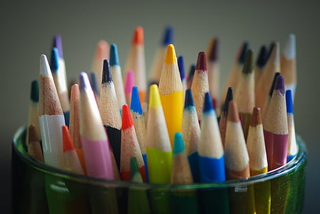 assorted-color pens in green glass cup thumbnail