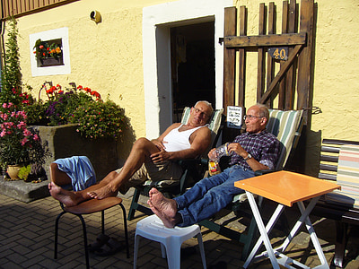 two men sitting on lounge outdoor thumbnail