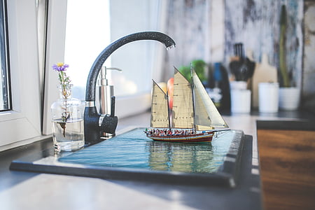 black faucet beside brown and white sailboat scale model thumbnail