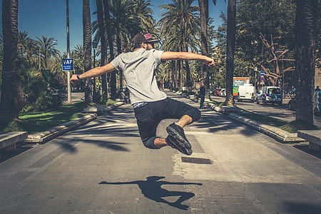 man jumping on road during daytime thumbnail