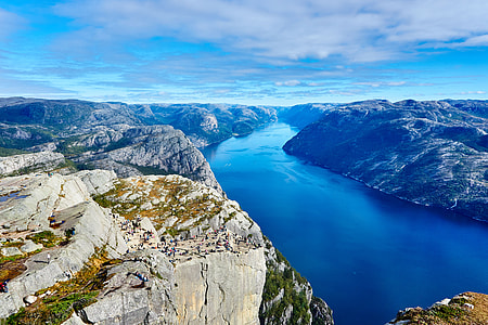 body of water in middle of mountains under blue and white sunny sky during daytime thumbnail