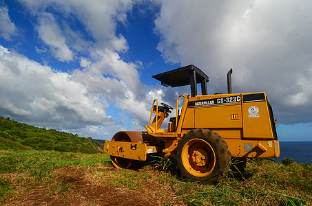 yellow Caterpillar road roller on green grass thumbnail