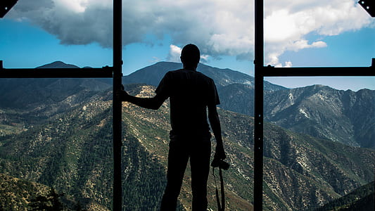 silhouette photography of man holding DSLR camera thumbnail
