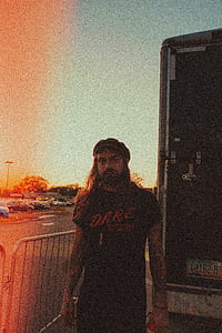 man wearing black t-shirt near white box truck at daytime thumbnail