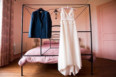 Men's black dress coat and Women's white sleeveless dress thumbnail