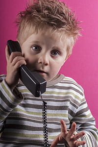 boy taking call near pink wall thumbnail