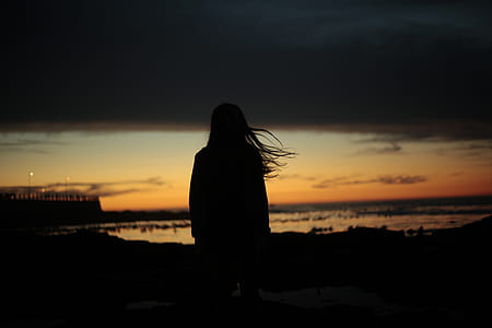 silhouette of person facing body of water photograph thumbnail