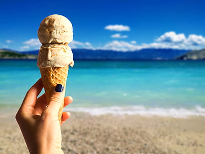 shallow focus photo of person holding ice cream thumbnail
