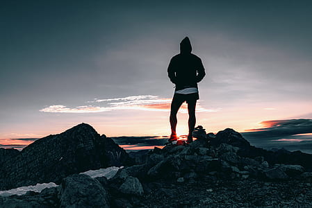 man standing on stone during sunset thumbnail