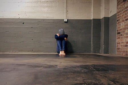 person sitting near gray wall thumbnail