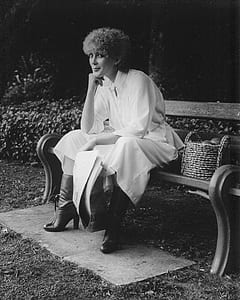 grayscale photography of woman sitting on bench thumbnail