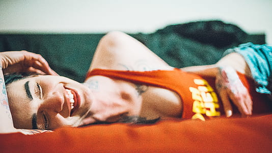 smiling and lying woman wearing red tank top thumbnail