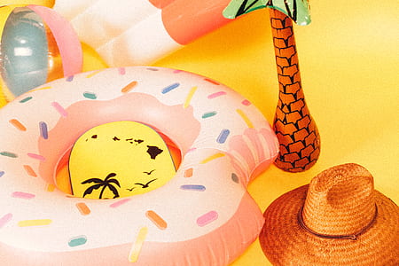 pink doughnut pool floats near brown straw hat thumbnail