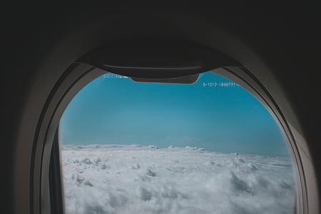 airplane glass window overlooking clouds thumbnail