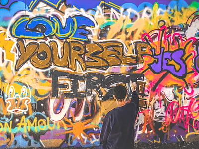man spraying graffiti art on wall thumbnail