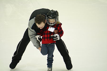man teaching ice hockey skates to boy thumbnail