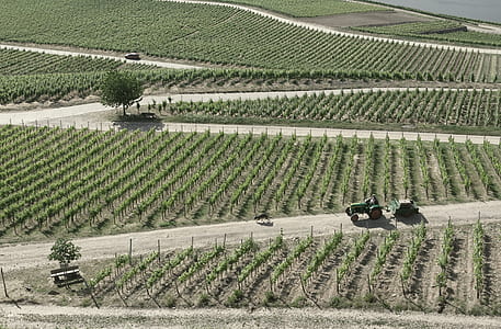 aerial photography of tractor moving on road near field thumbnail
