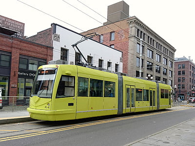 yellow train beside white and brown building thumbnail