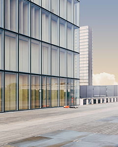 person lying on ground beside curtain wall building thumbnail