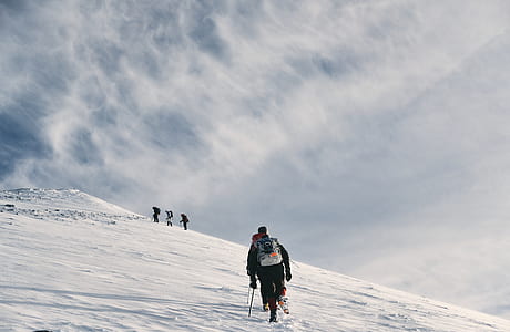 man walking towards mountain covered by snow thumbnail