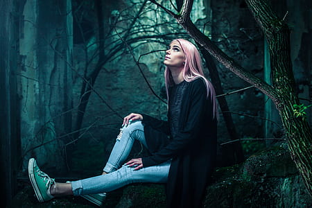 woman wearing black long-sleeved shirt sitting on the rock surrounded by trees thumbnail