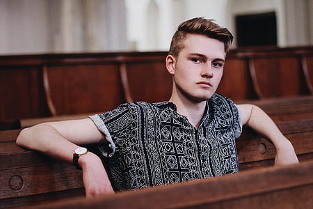 man in grey and black button-up shirt sitting on bench thumbnail