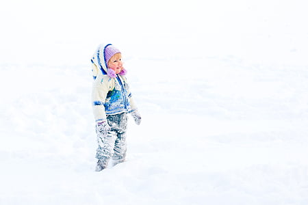 toddler girl standing on snow covered ground thumbnail