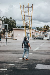 man standing while trying to balance A-frame ladder thumbnail