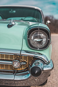 close up photography of teal vehicle headlight at daytime thumbnail