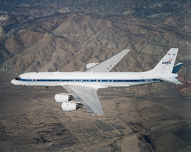 white and blue NASA plane above mountains thumbnail