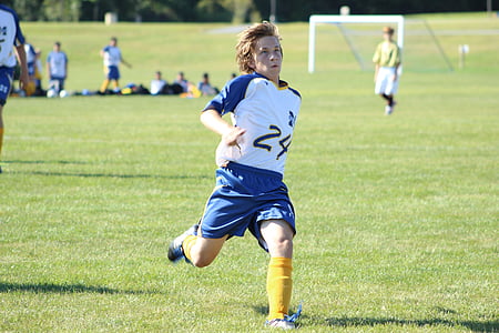 boy playing soccer on field at daytime thumbnail