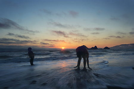 person and toddler on seashore during golden hour thumbnail