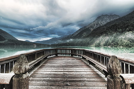 brown dock near mountain and body of water during daytime thumbnail