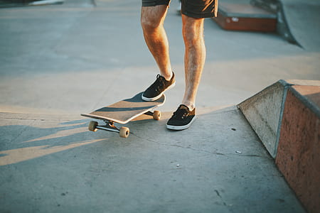 man standing beside skateboard thumbnail