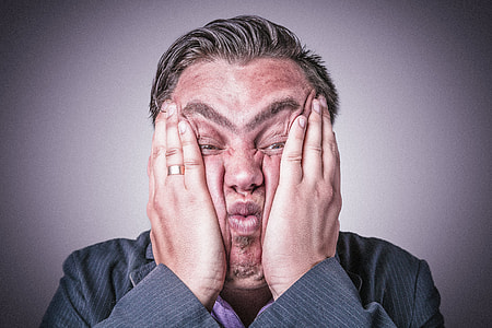 photo of man in gray suit holding face thumbnail