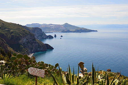 mountains near sea at daytime thumbnail